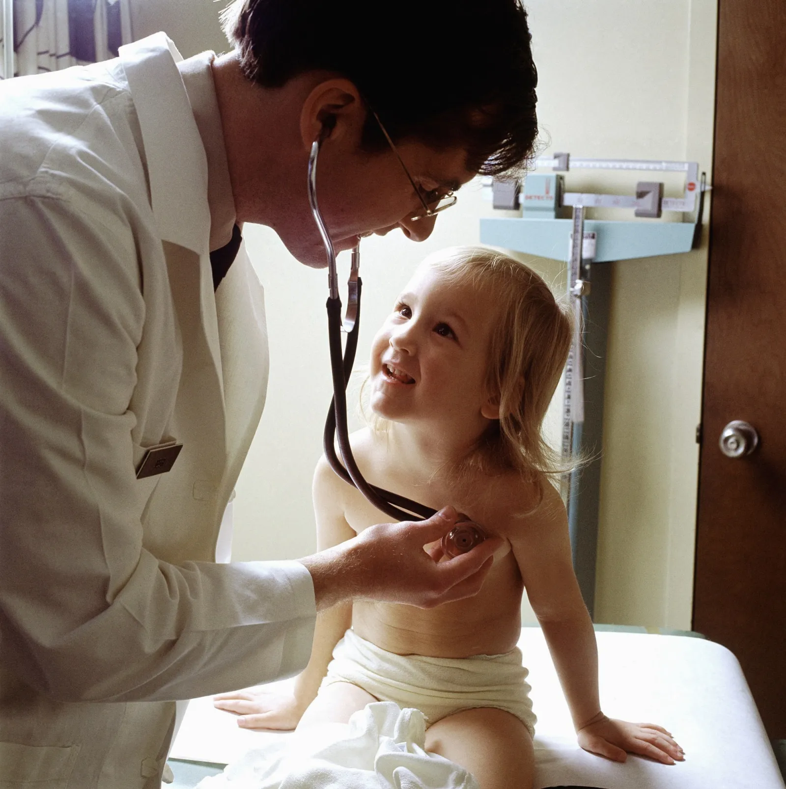 Médico examinando um jovem paciente com estetoscópio