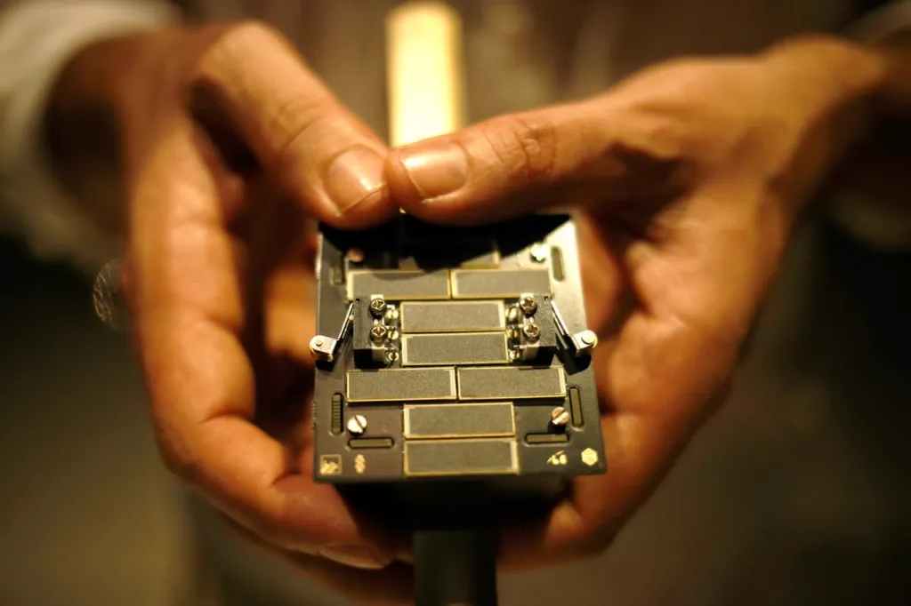 Mãos segurando um satélite no formato PocketQube